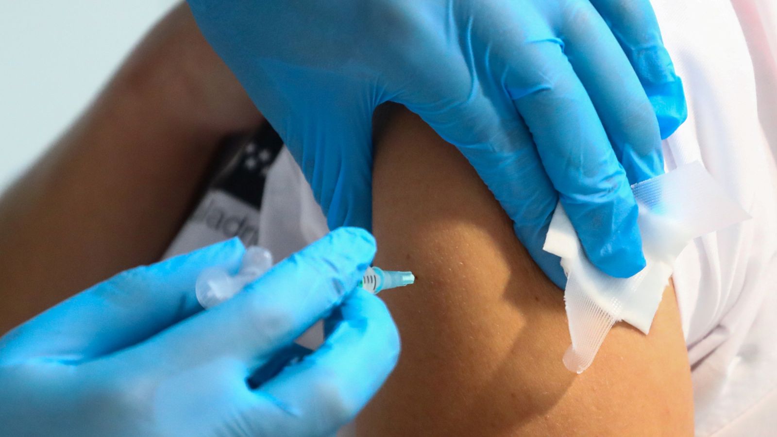 Sanitari subministrant una dosi de la vacuna de Pfizer