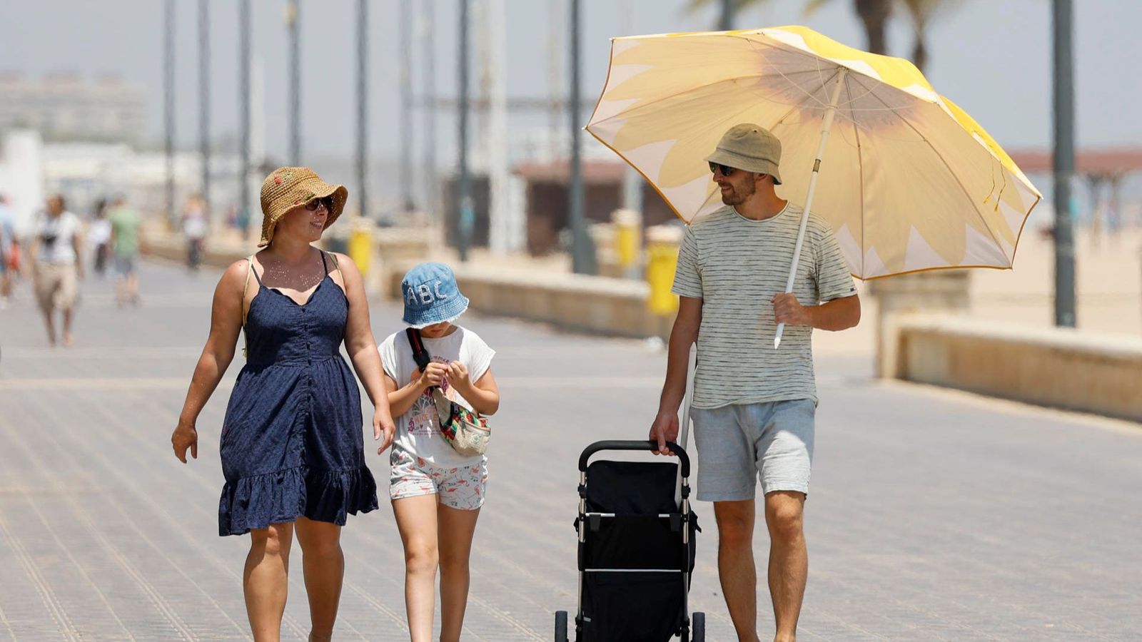 Diverses persones caminen pel passeig de la platja de la Malva-rosa