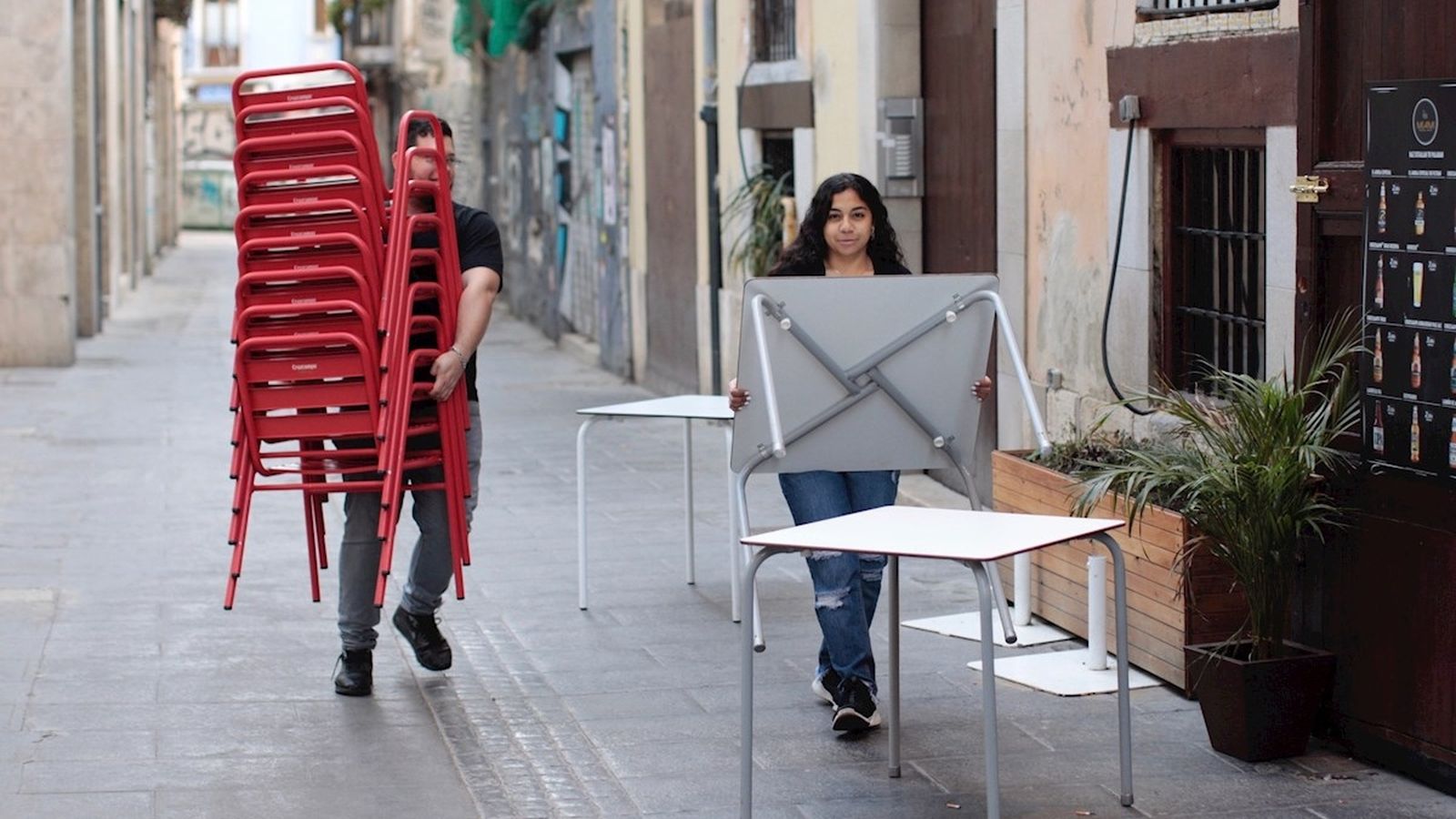 Treballadors de la restauració arrepleguen taules i cadires