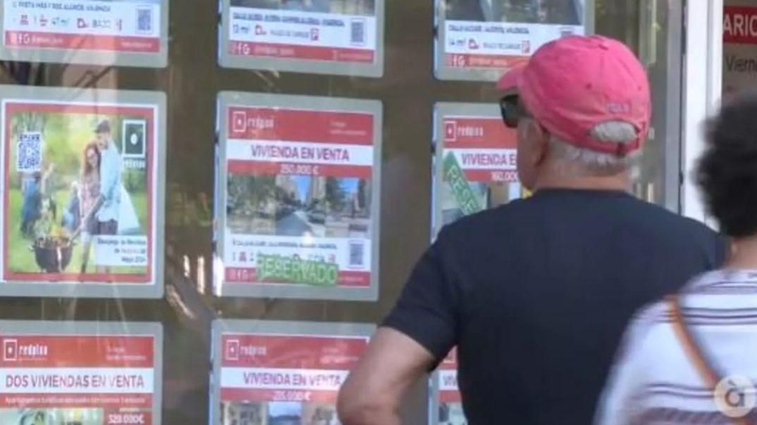 Un home mira preus d'habitatges en l'aparador d'una immobiliària / À Punt NTC