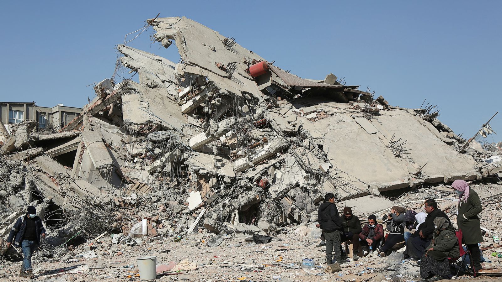 Un grup de persones al costat dels enderrocs d'un edifici a la ciutat turca d0Adiyaman