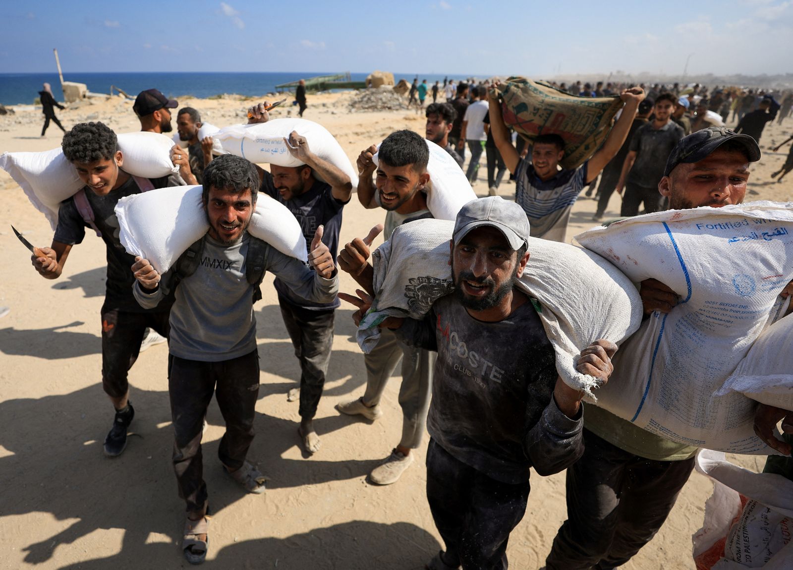 Uns palestins carreguen sacs de farina en una entrega a Beit Lahia