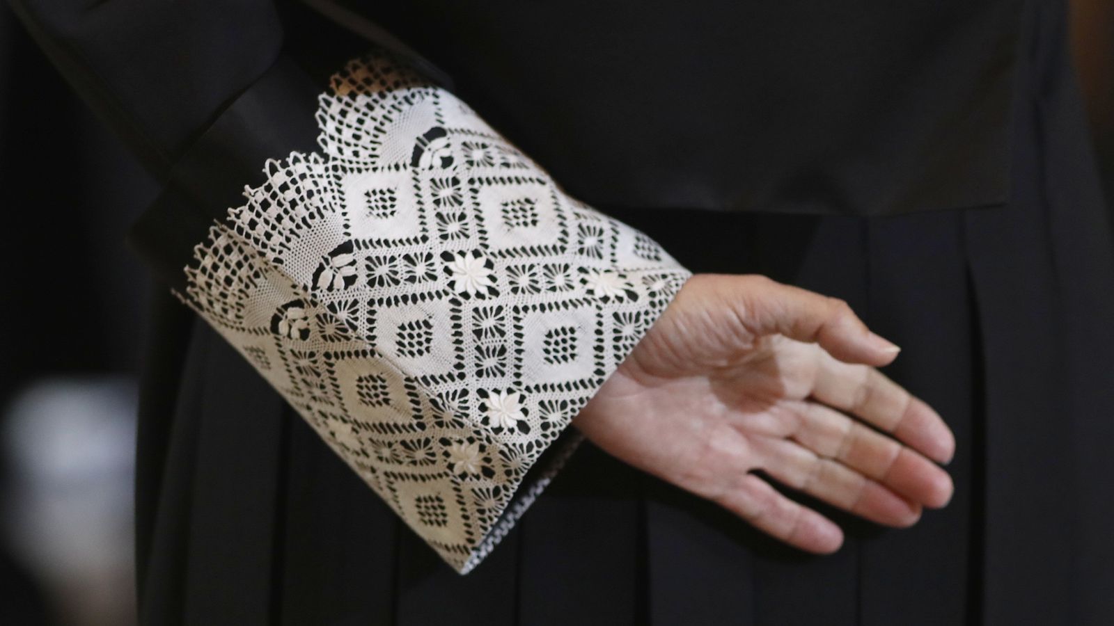 Imatge de la mà d'un jutge, amb la toga negra que vesteixen en les vistes orals.