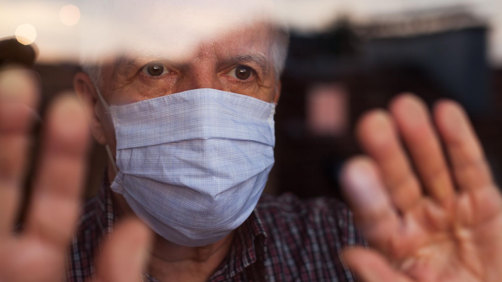 Home d'avançada edat mira per la finestra durant el confinament
