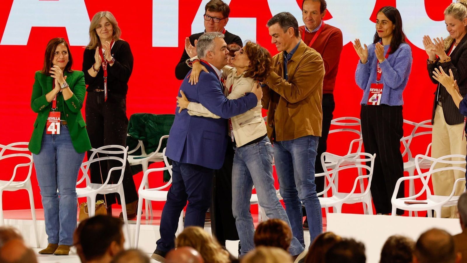 El secretari d'organització del PSOE, Santos Cerdán, abraça la vicepresidenta primera, María Jesús Montero, en presència del secretari general del partit, Pedro Sánchez