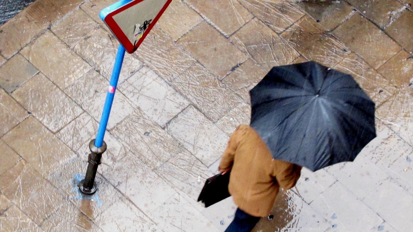 Una persona amb un paraigua al carrer en una imatge d'arxiu