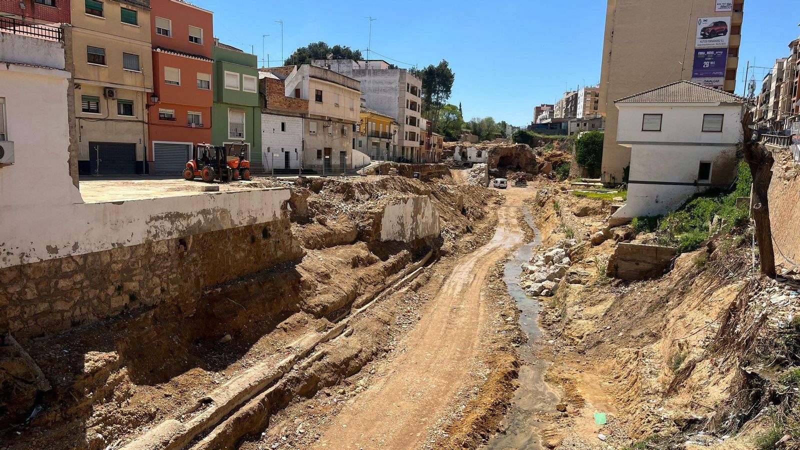 Treballs de reparació al barranc de Xiva, després de l'enderrocament d'alguns dels habitatges danyats per la barrancada, a l'esquerra de la imatge