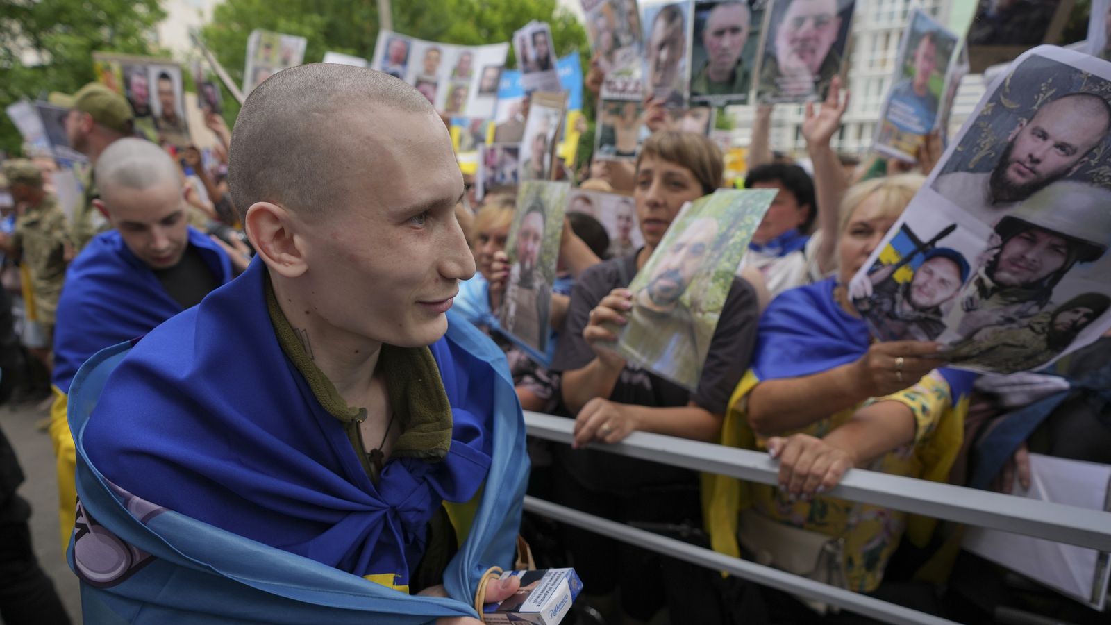 Ucraïnesos mostren retrats dels seus familiars desapareguts als presoners de guerra alliberats després d'un intercanvi de presoners amb Rússia