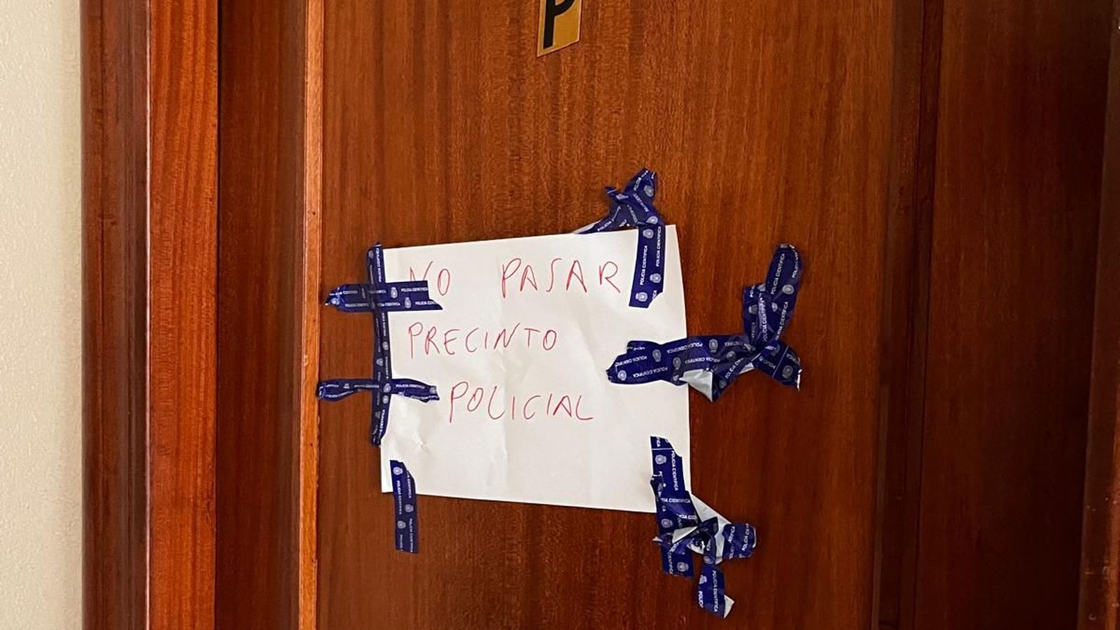 Cartell penjat en la vivenda precintada on residia el policia retirat amb la família que acollia
