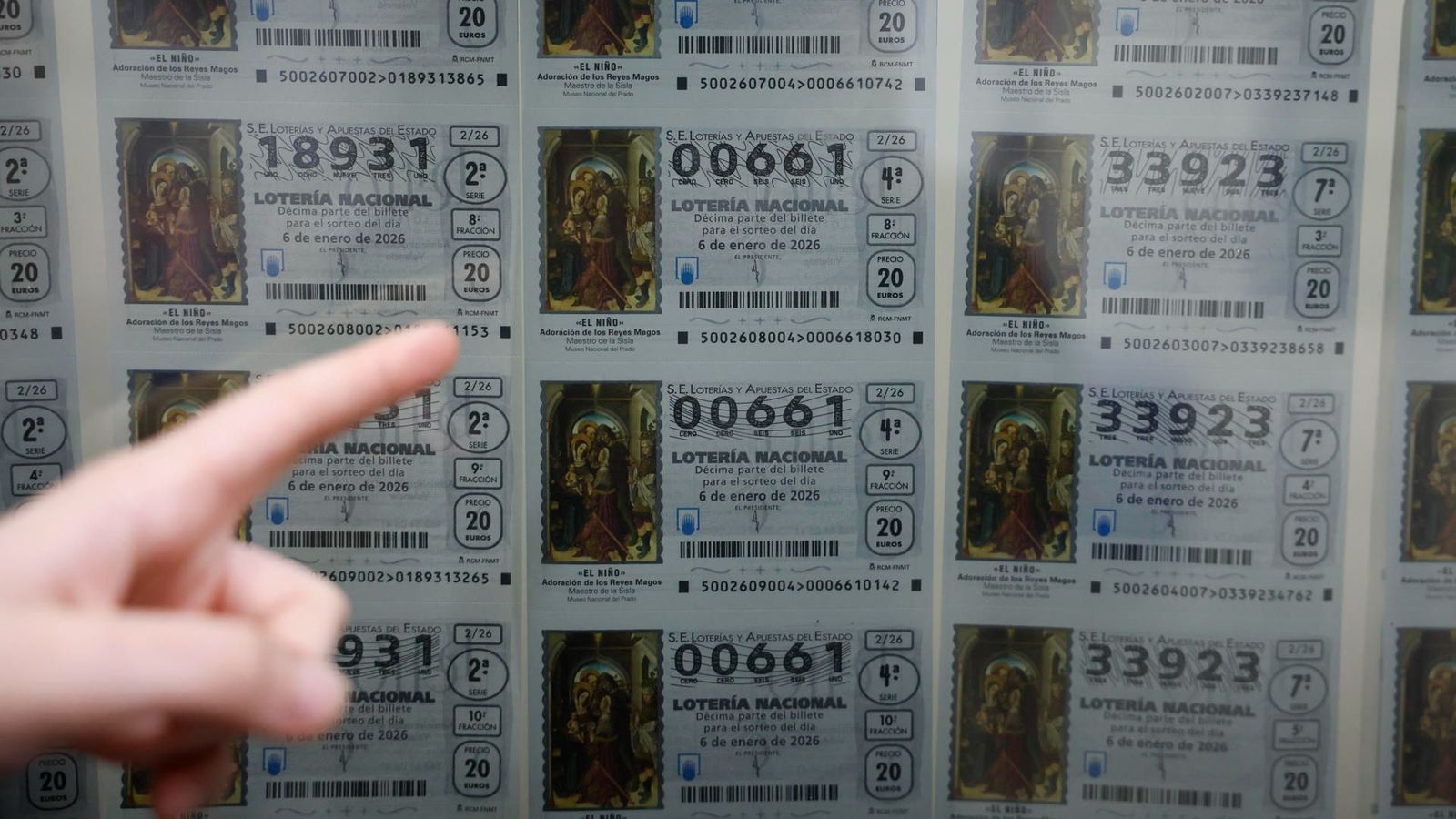 Un client apunta a un dècim exposat darrere de la finestreta d'una administració de loteria de València