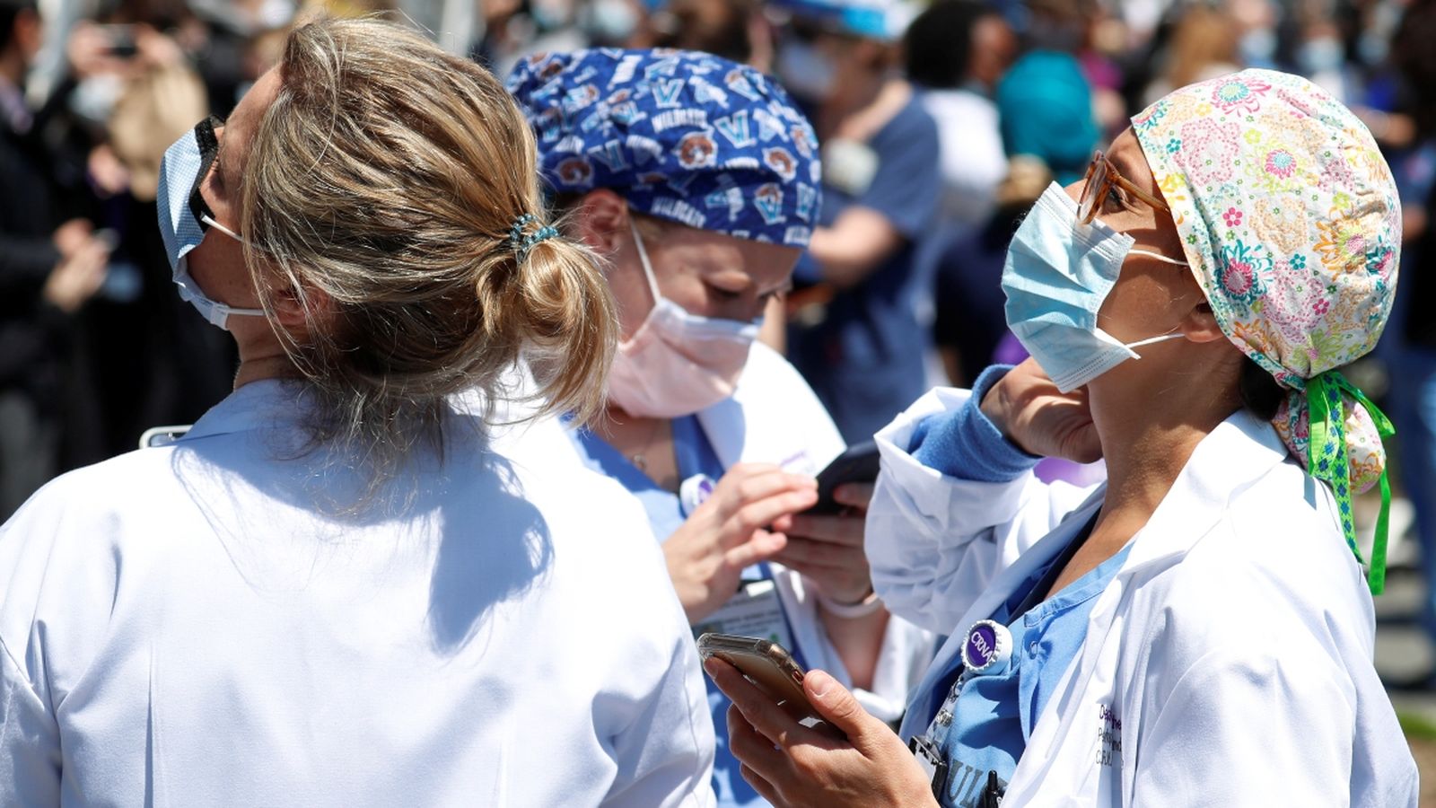 Treballadores sanitàries de la ciutat de Nova York consulten els seus telèfons mòbils, en una imatge d’arxiu del passat 28 d’abril