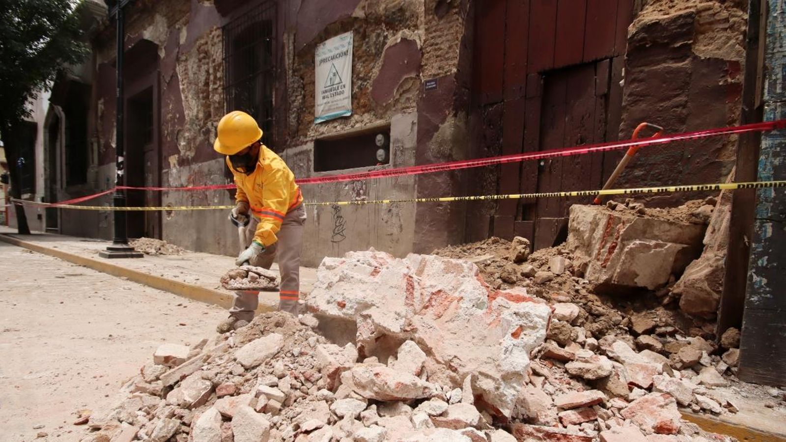 Un obrer treu les restes d'un edifici danyat durant el terratrémol, a Oaxaca