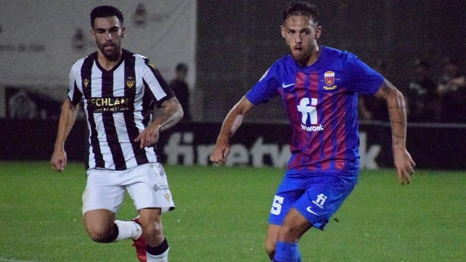 Dos futbolistes es disputen la ilota