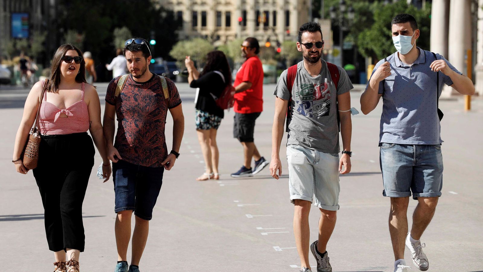 Diverses persones passegen pel centre de València sense mascareta