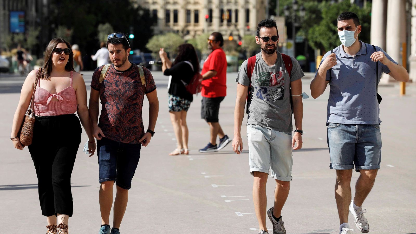 Diverses persones passegen pel centre de València sense mascareta