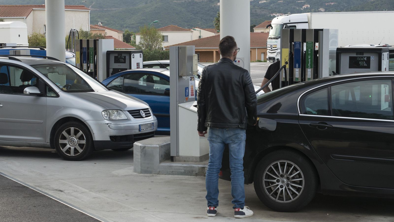 Un home resposta el seu vehicle en una gasolinera