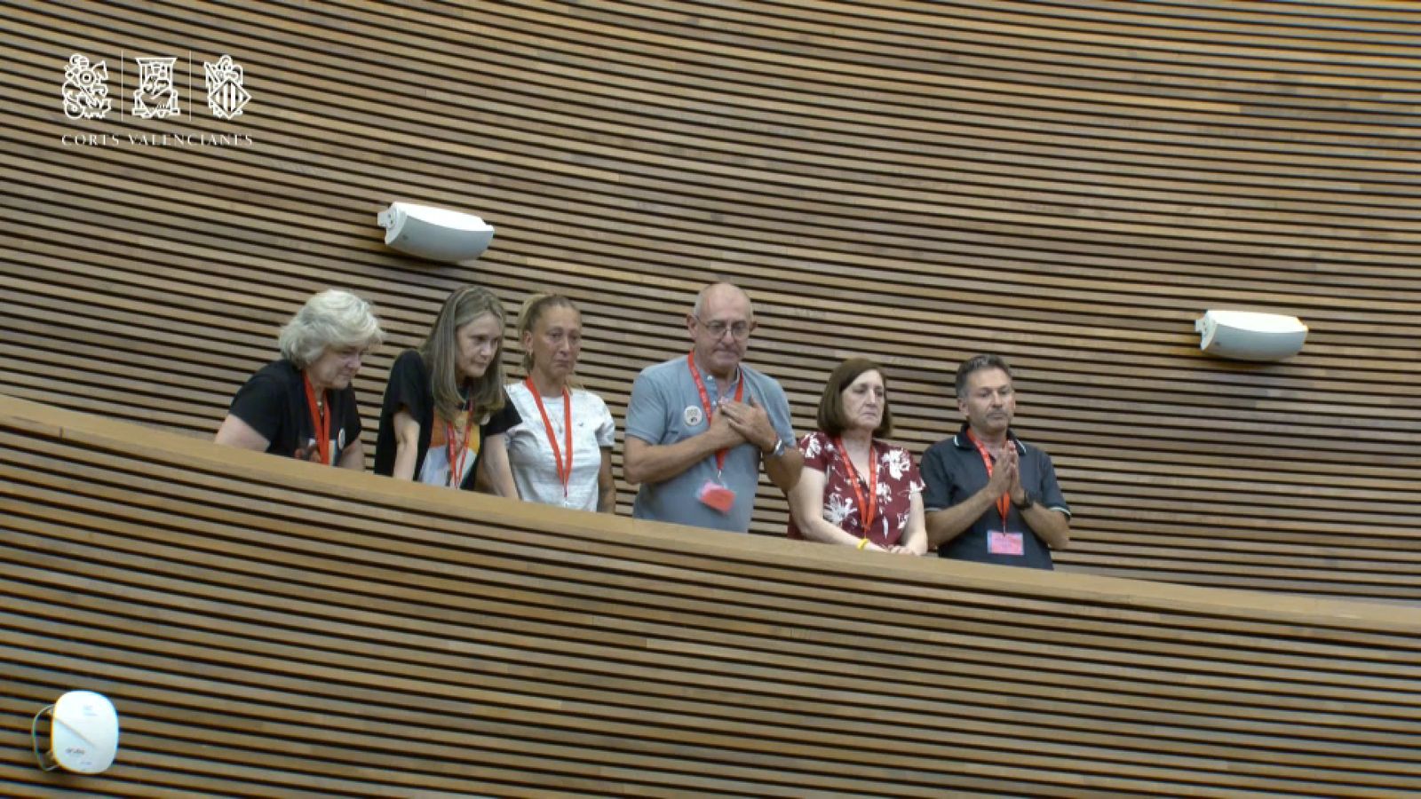 En imatge, representants de les associacions majoritàries de les víctimes en la tribuna de convidats responen als aplaudiments de part de l'hemicicle