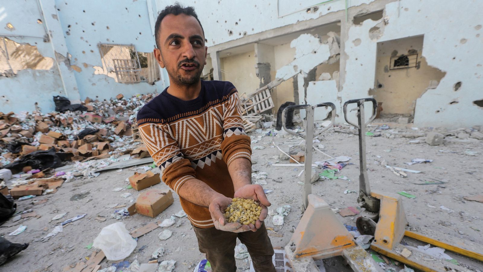 Un palestí mostra un gapat de pasta en un punt d'entrega d'ajuda bombardejat per Israel en el camp de refugiats d'Al-Nuseirat en el centre de la Franja de Gaza