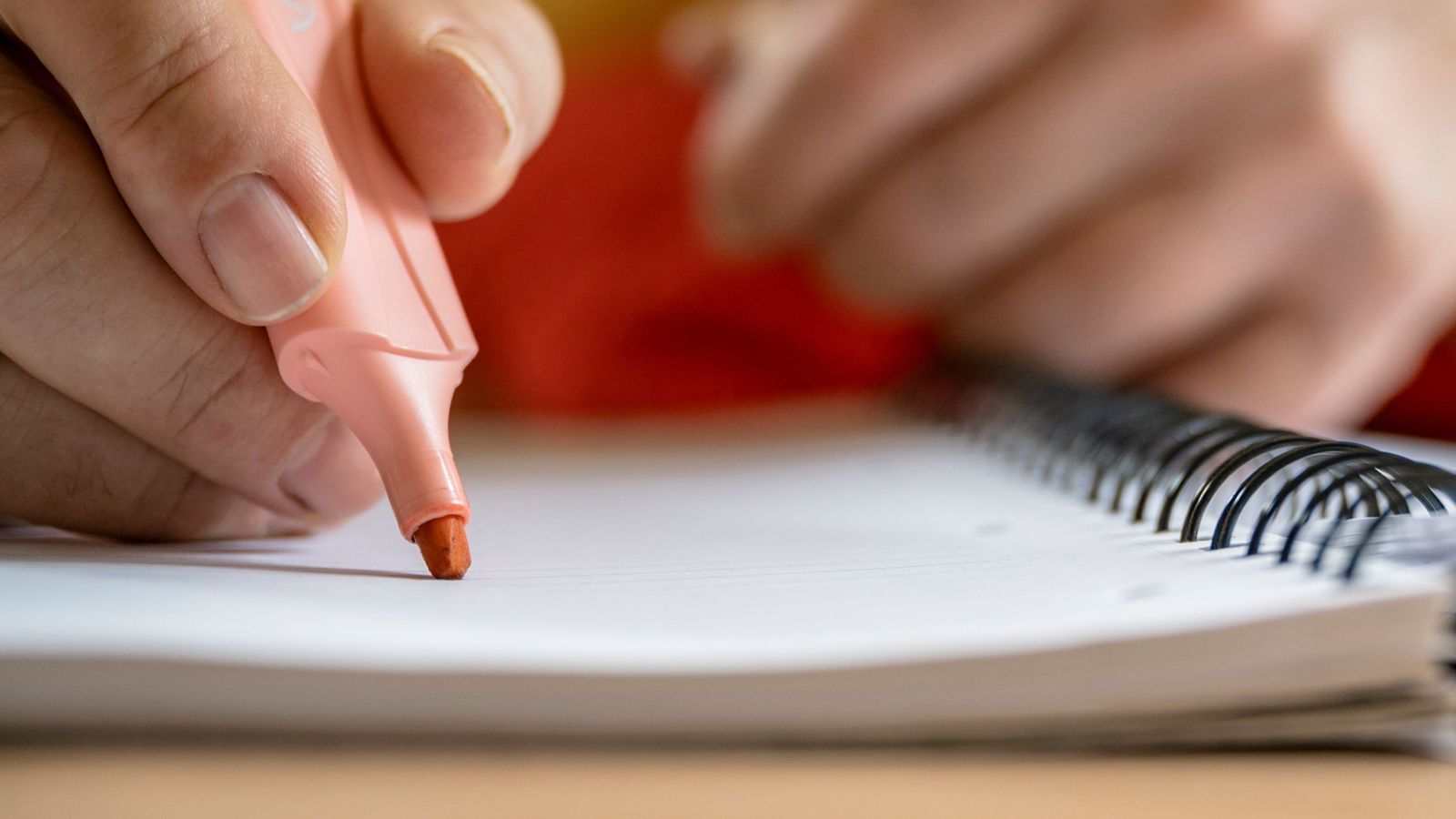 Una alumna amb un marcador subratlla en una llibreta