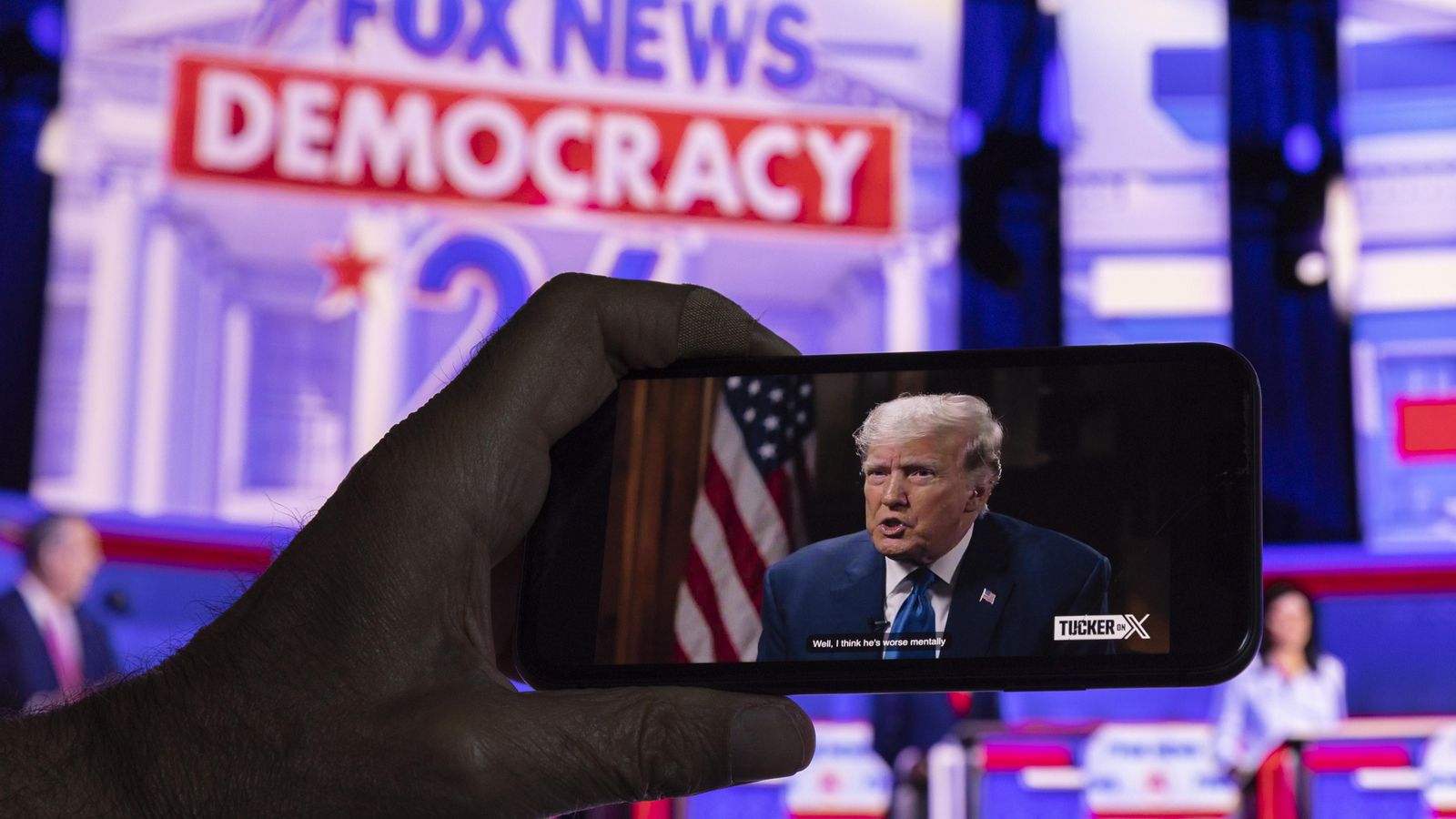 Un espectador observa el primer debat presidencial republicà en viu en Fox News i l'entrevista a l'expresident i candidat Donald Trump realitzada per Tucker Carlson en Twitter