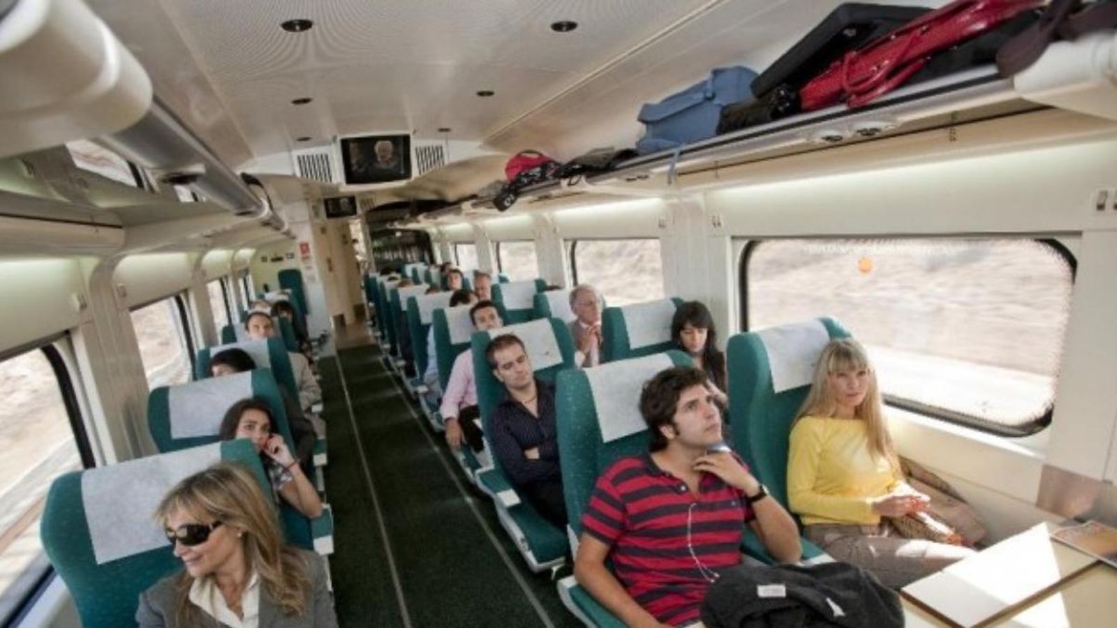 Imatge d'arxiu de passatgers al tren amb maletes en la part superior