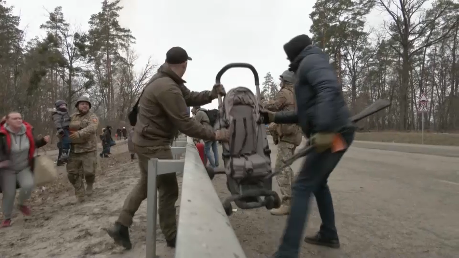 Els militars ajuden una família a creuar amb el seu bebé 