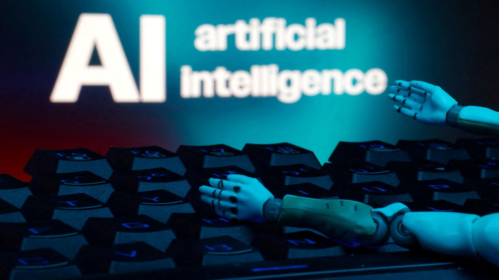 De fons, un rètol on posa 'Intel·ligència artificial', amb un teclat i unes mans de robot