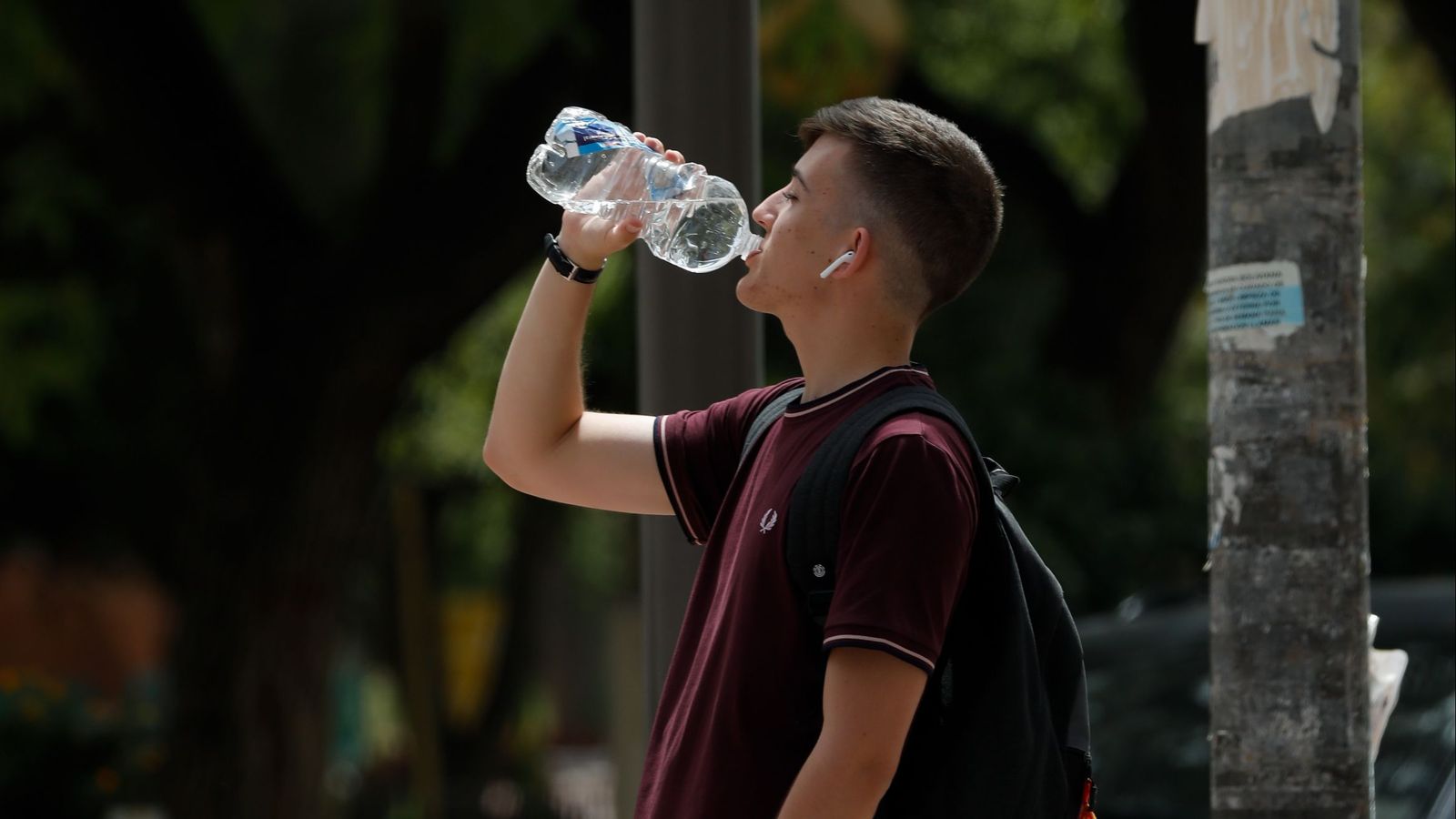 Un jove beu aigua davant les altes temperatures en una imatge d'arxiu