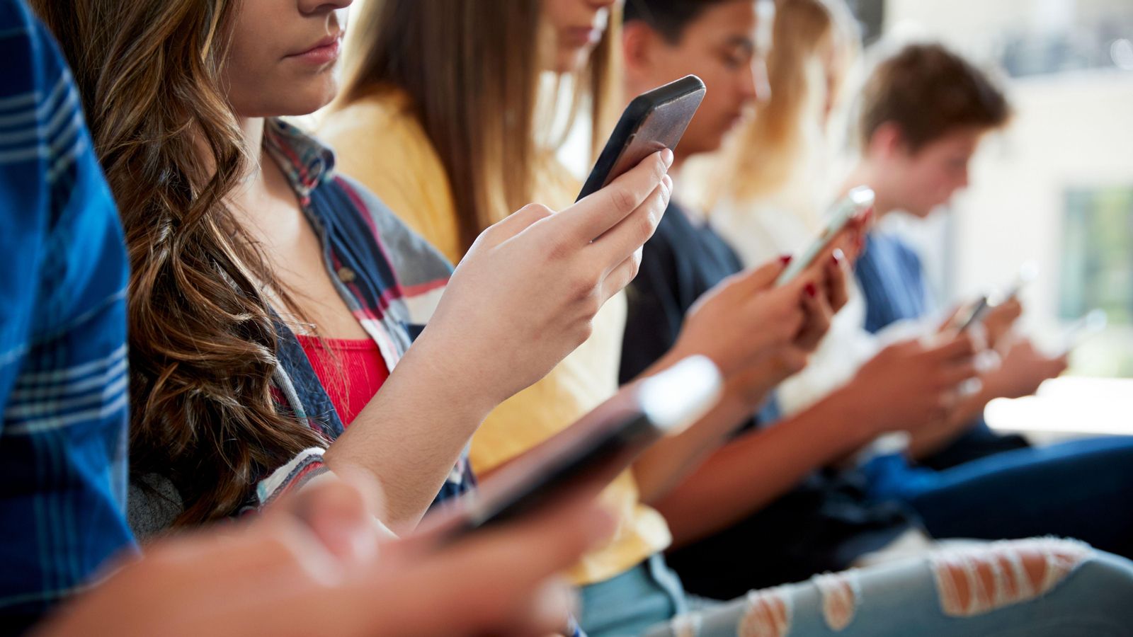 Imatge d'arxiu d'uns adolescents amb el telefon a classe