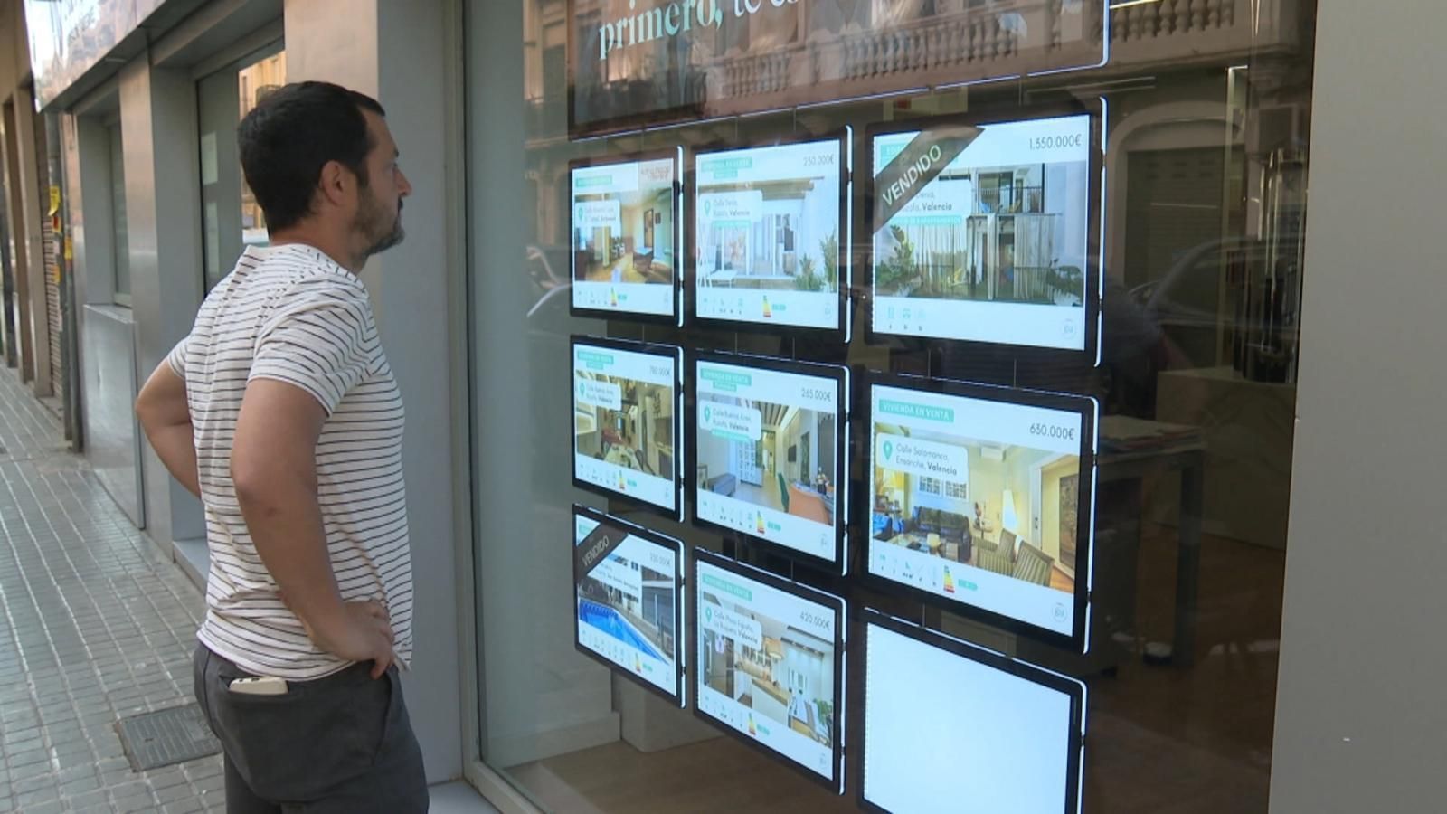 Un home consulta els preus de les vivendes en una immobiliària Un home consulta els preus de les vivendes en una immobiliària