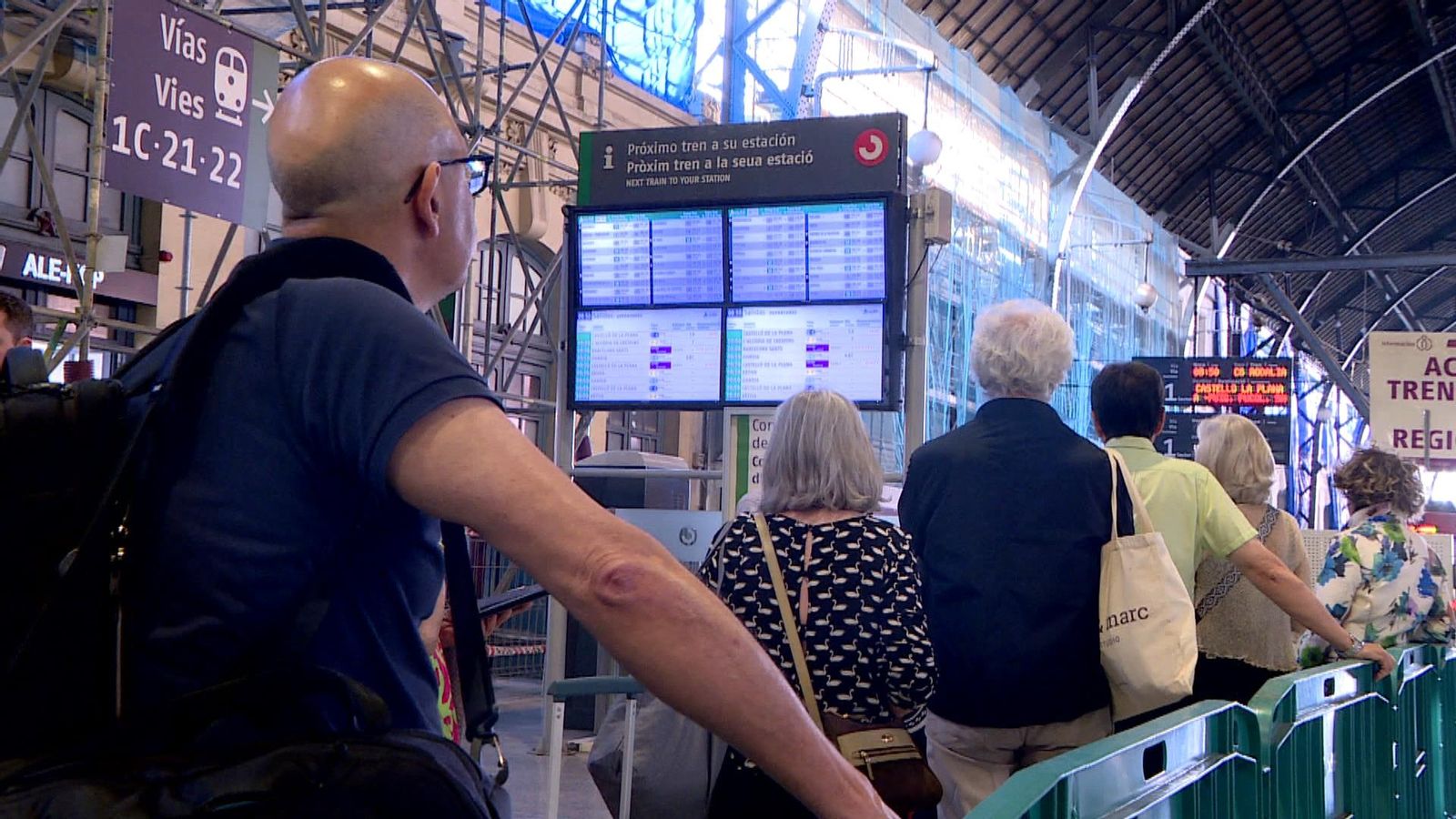 Usuaris consulten el panell de l'horari dels trens
