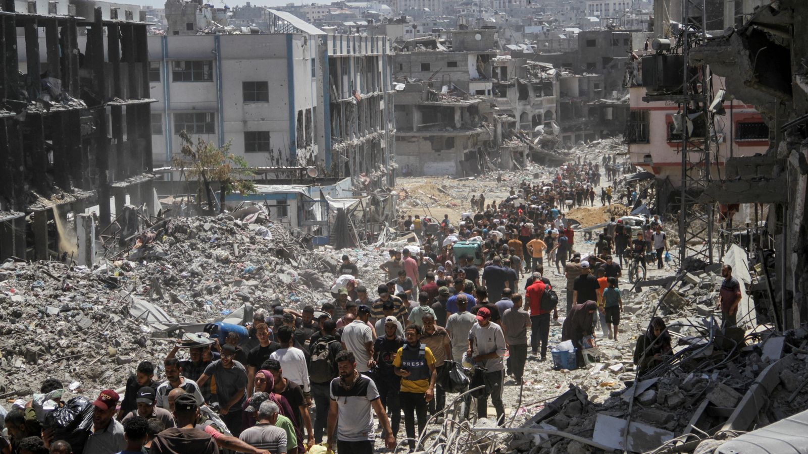 Un grup de palestins de camí cap a una entrega d'aliments entre els enderrocs de Khan Younis, al sud de la Franja de Gaza