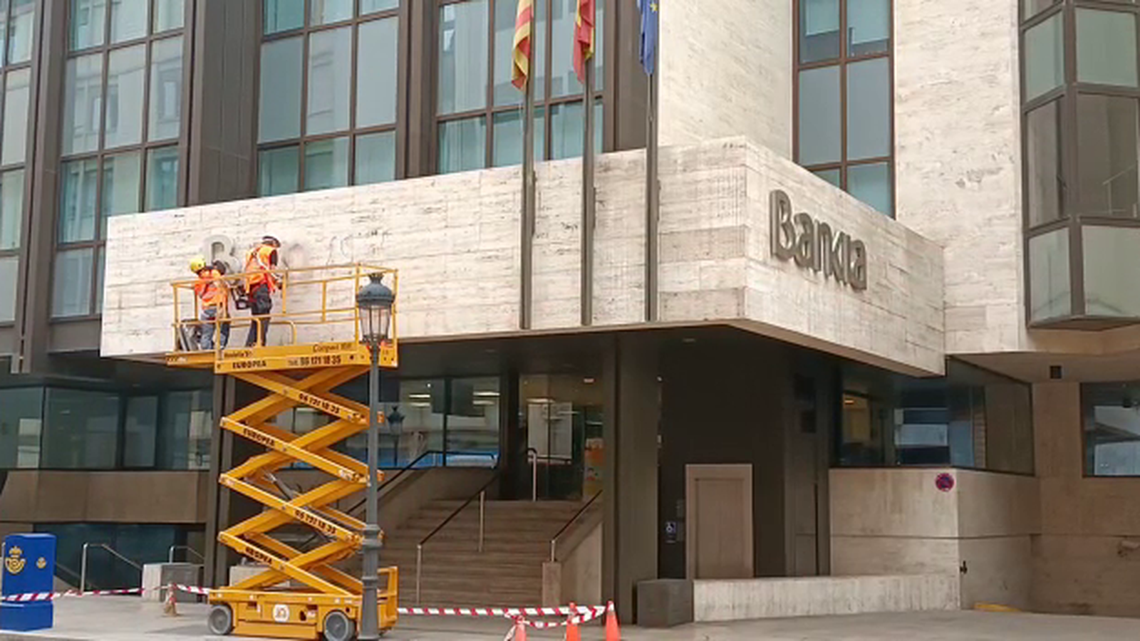 Un grup d’operaris han començat a desmuntar les lletres del logotip de Bankia