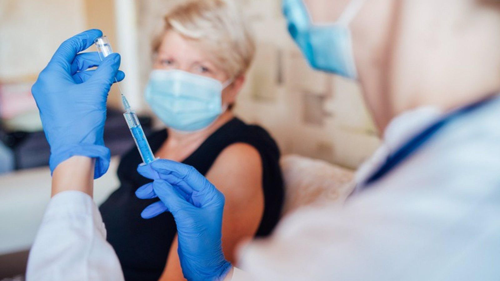Un treballador sanitari a punt de vacunar a una pacient