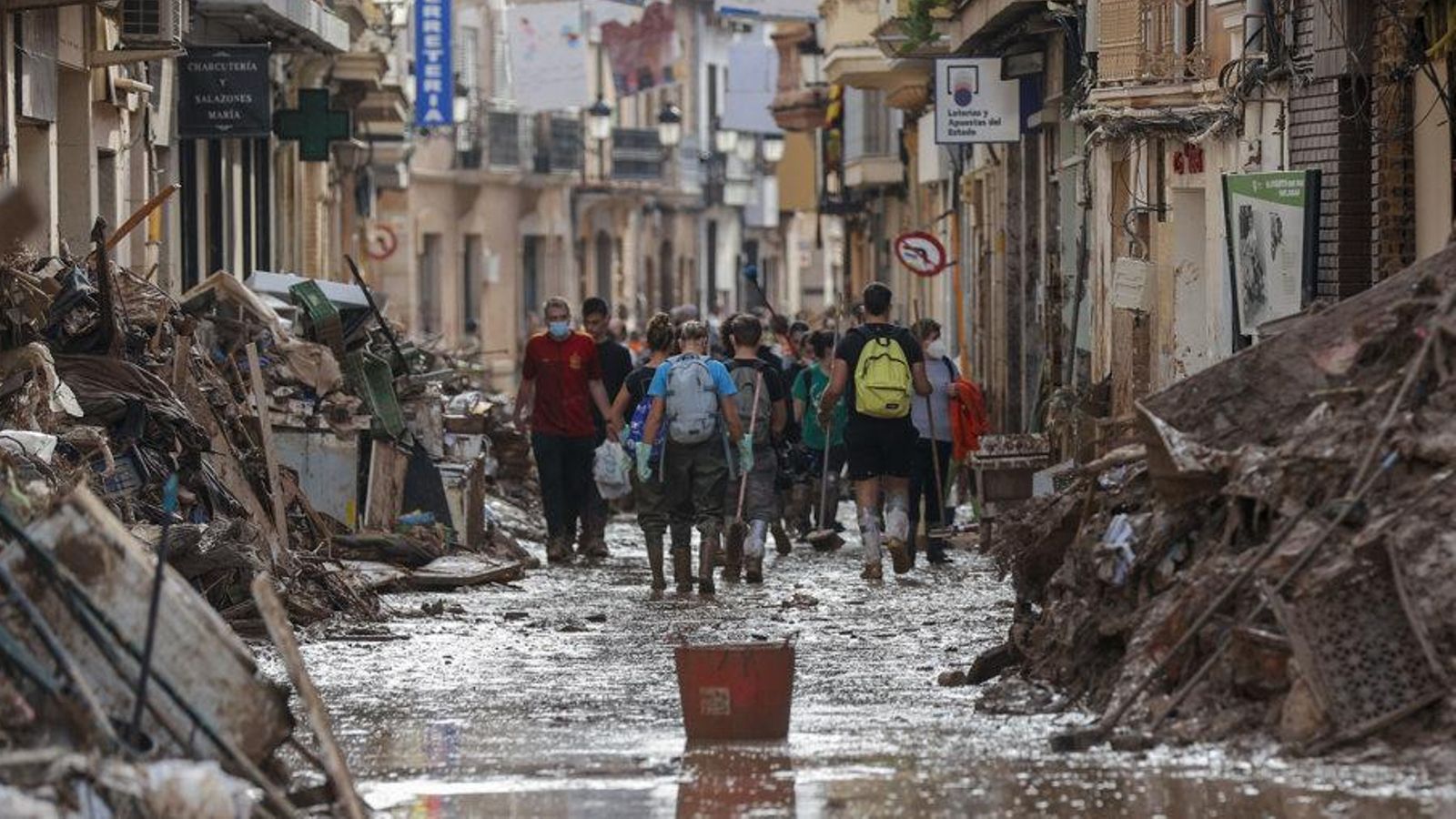 Veïns i voluntaris de neteja transiten pels carrers enfangats de Paiporta, una setmana després de la DANA