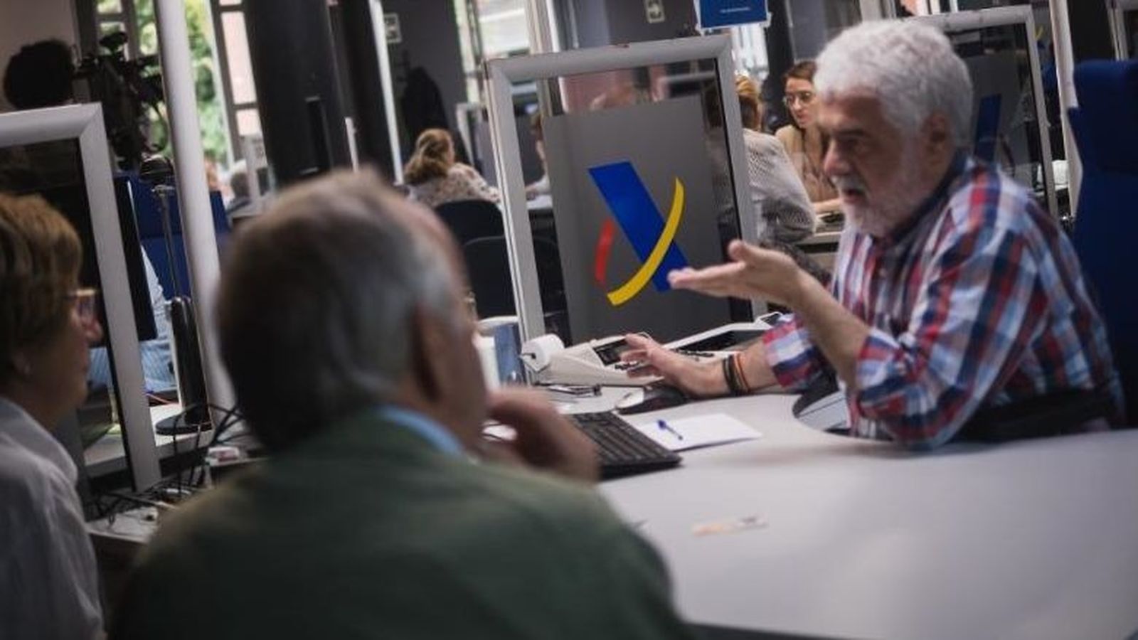 Un tècnic ajuda a fer la declaració de la renda presencial a un matrimoni