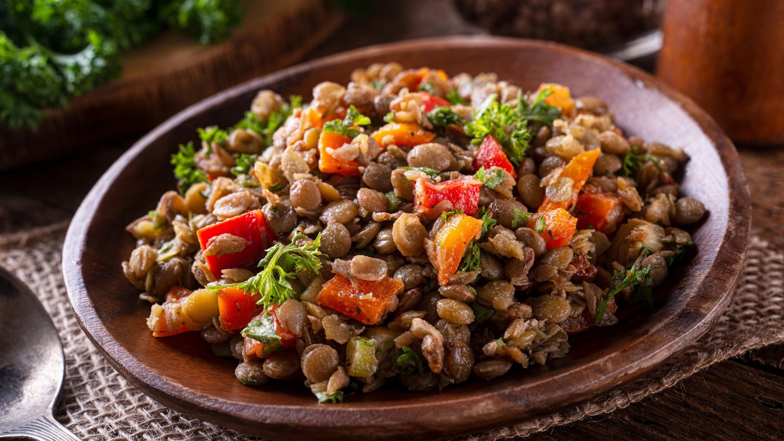 Ensalada de llentilles mediterrànies que tenen ferro combinades amb pimentons rojos, tomaca i julivert, rics amb vitamina C