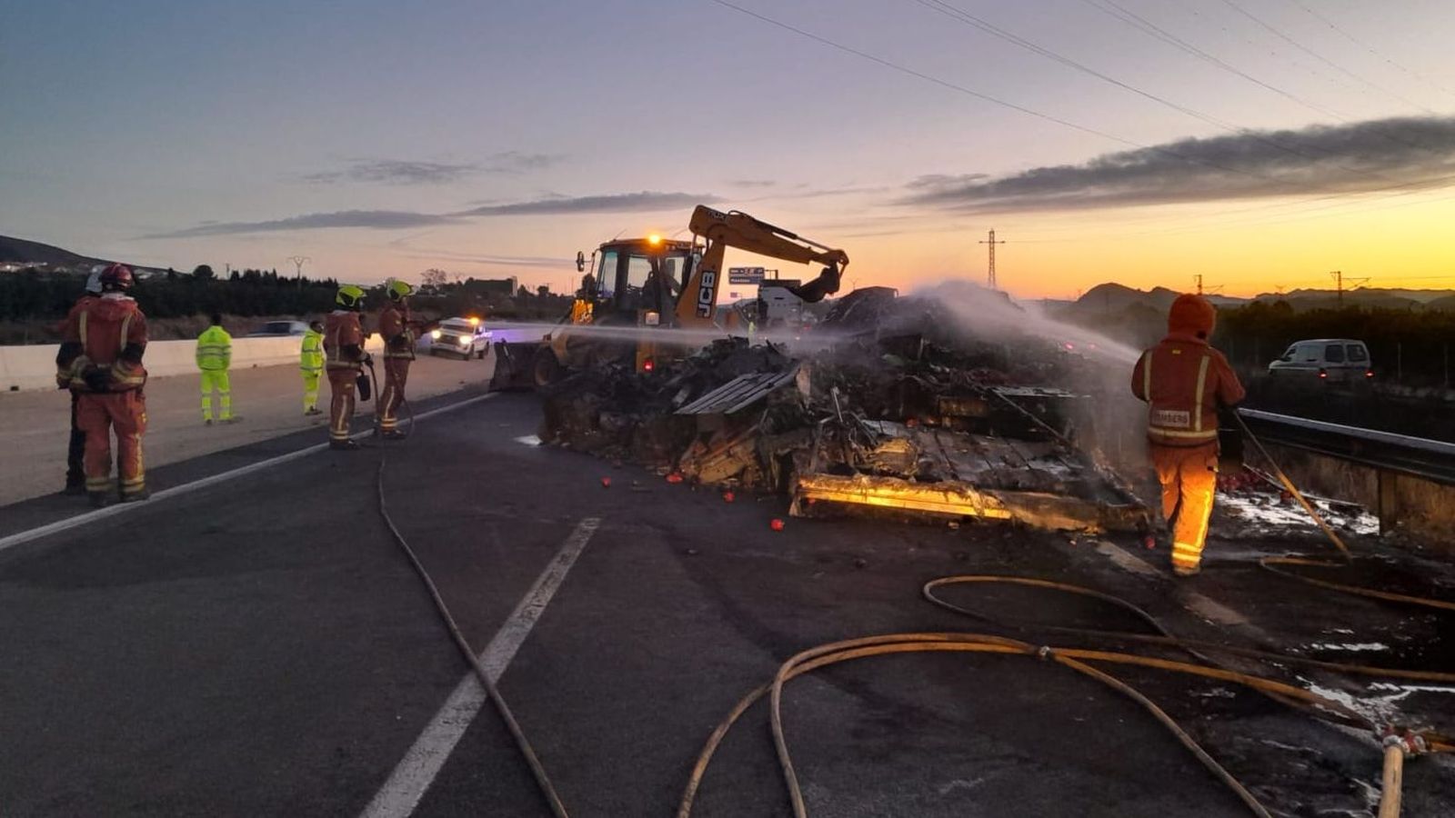 Els bombers tracten d'extingir l'incendi del remolc del camió que s'ha incendiat a l'altura de Montesa