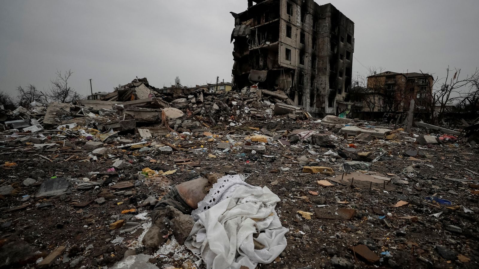 Un cadàver jau entre els enderrocs d'un edifici destruït per l'aviació russa