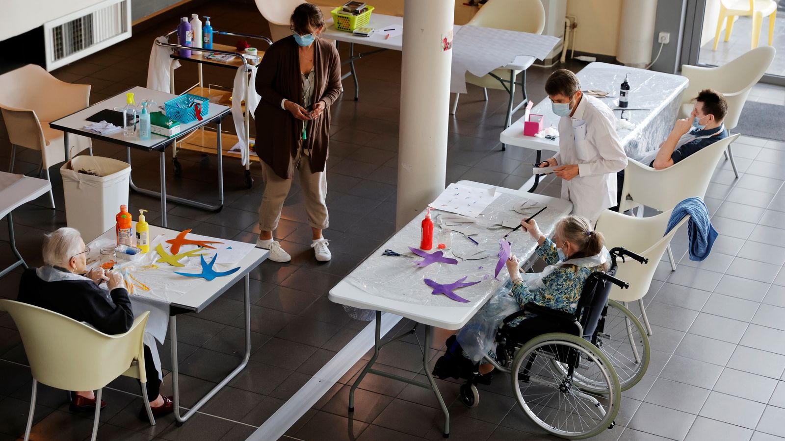 Diversos resident d'un centre per a majors del Regne Unit fan manualitats junt als treballadors del centre