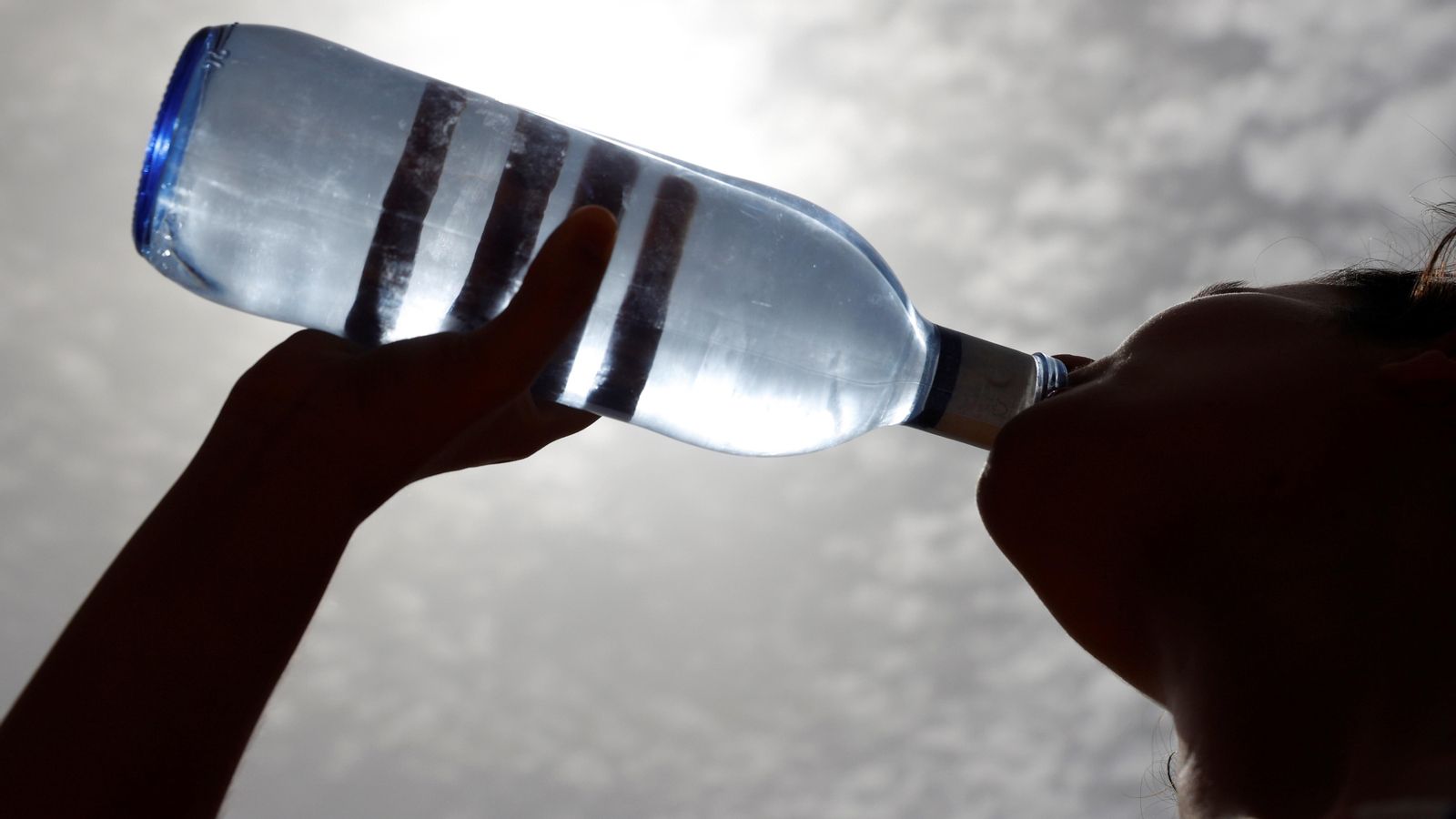 Una vianant beu aigua a les portes de la primera onada de calor de l'estiu