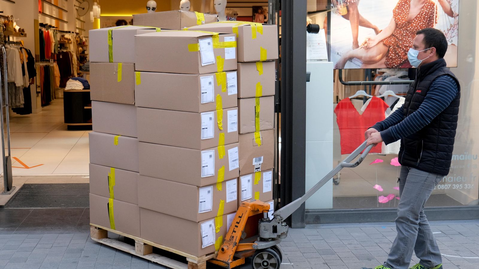 Un treballador d'un magatzem carregant caixes en una botiga a Brussel·les, Bèlgica