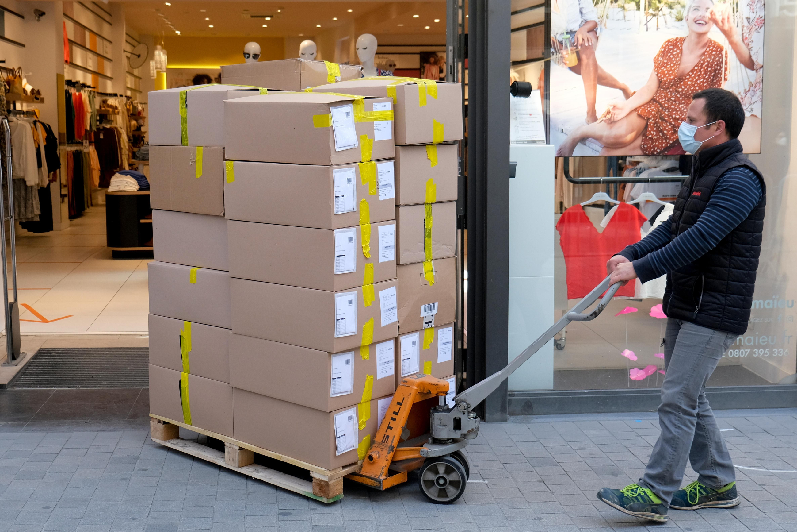 Un treballador d'un magatzem carregant caixes en una botiga a Brussel·les, Bèlgica Un treballador d'un magatzem carregant caixes en una botiga a Brussel·les, Bèlgica