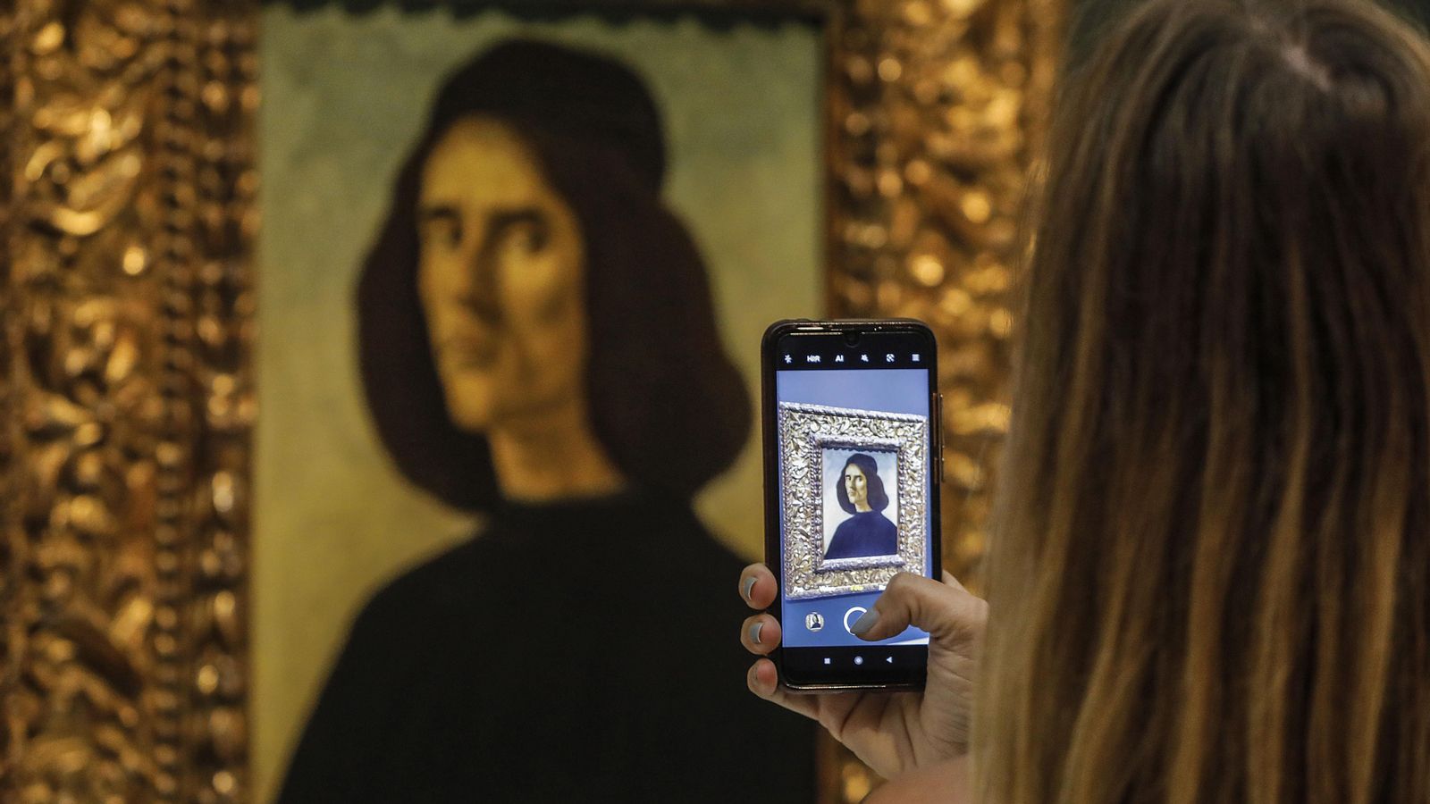 Una visitant fotografia el retrata de Botticelli que, des d'aquest dimarts, es pot observar al Museu de Belles Arts de València