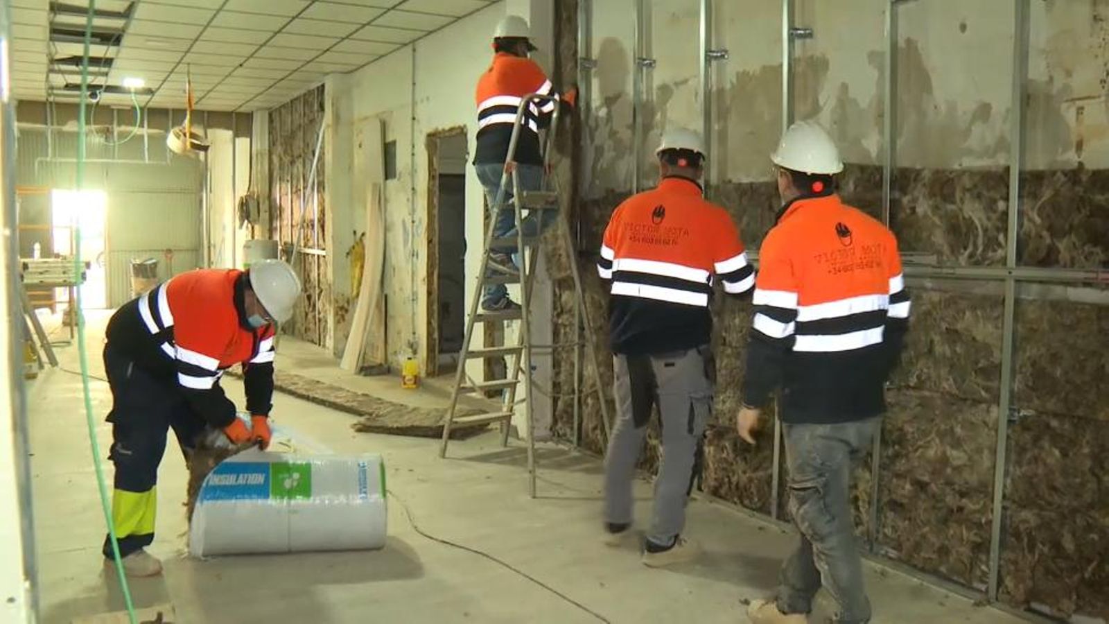 Operaris de la construcció treballant en l'aïllament d'una paret / Arxiu