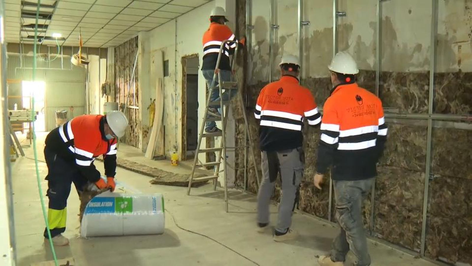 Operaris de la construcció treballant en l'aïllament d'una paret / Arxiu