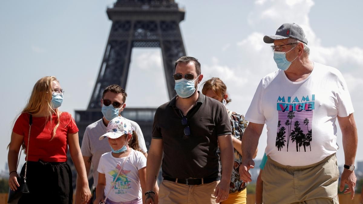Uns turistes amb mascareta, a les immediacions de la Torre Eiffel