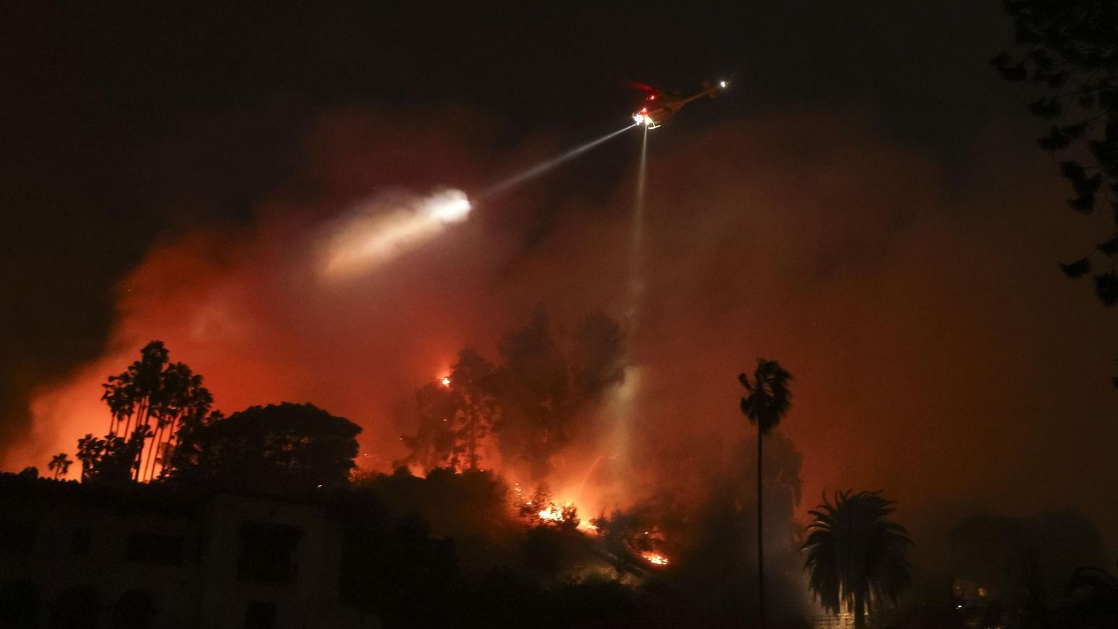 Els bombers lluiten per a controlar les flames a l'incendi declarat prop de Hollywood, a Los Angeles