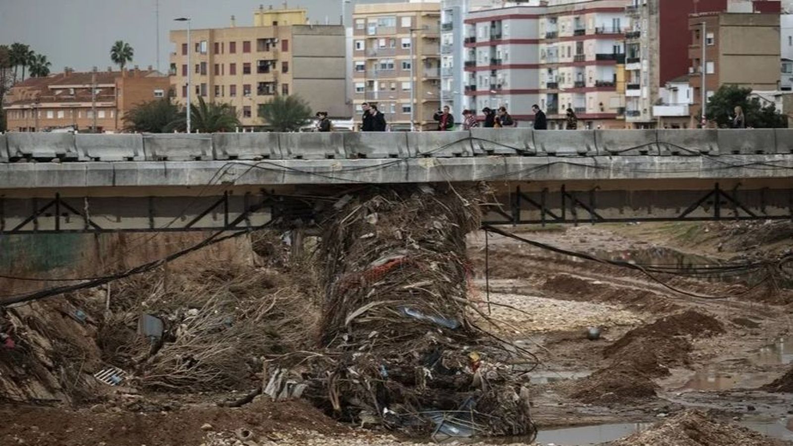 Diverses persones creuen per un pont del barranc del Poio a Paiporta en una imatge d'arxiu