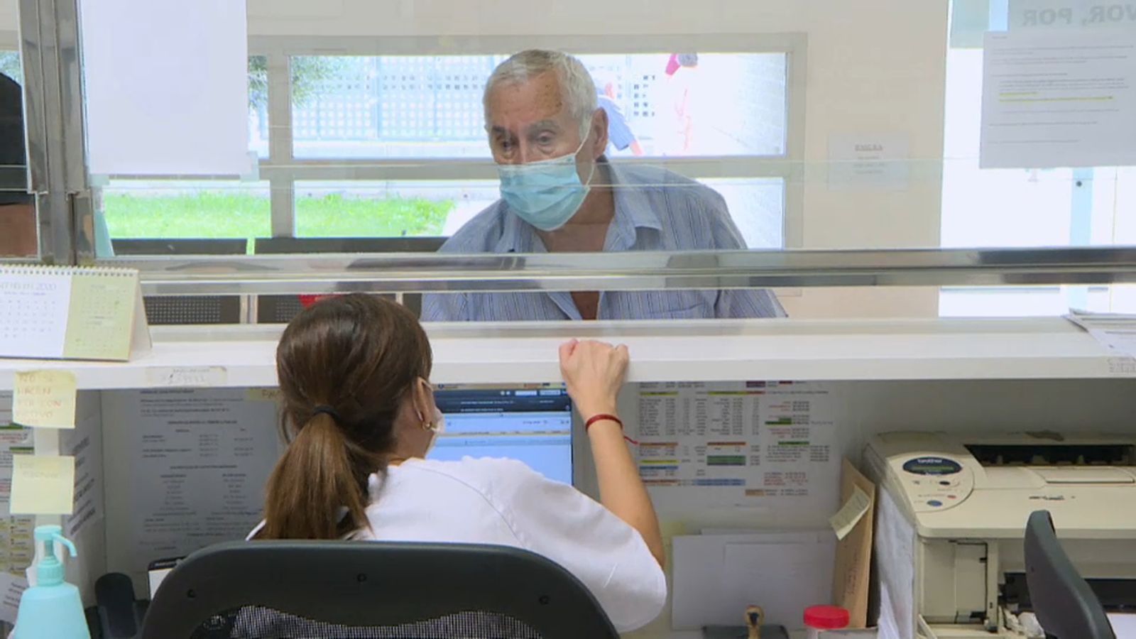 Un home és atés en la recepció d'un centre de salut